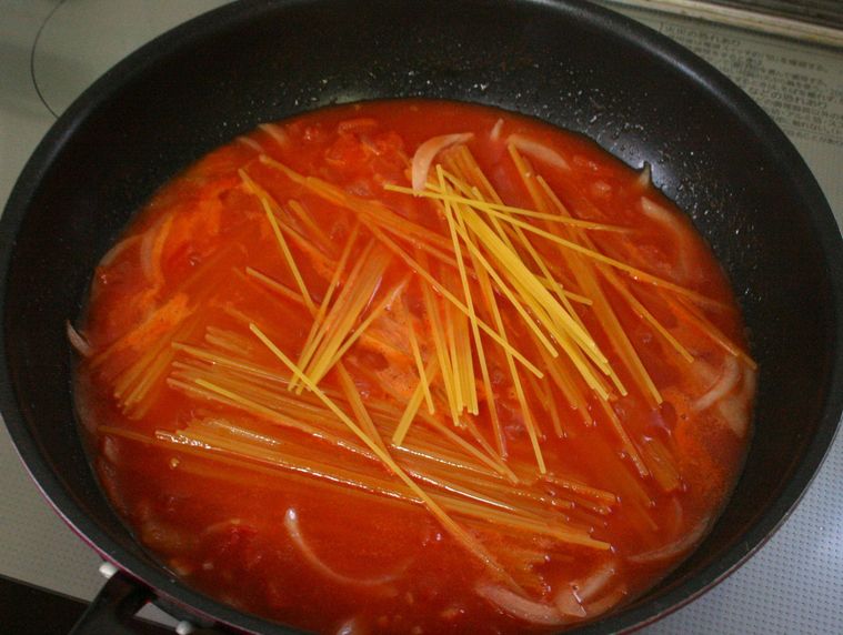 フライパンでスパゲッティをゆでている様子