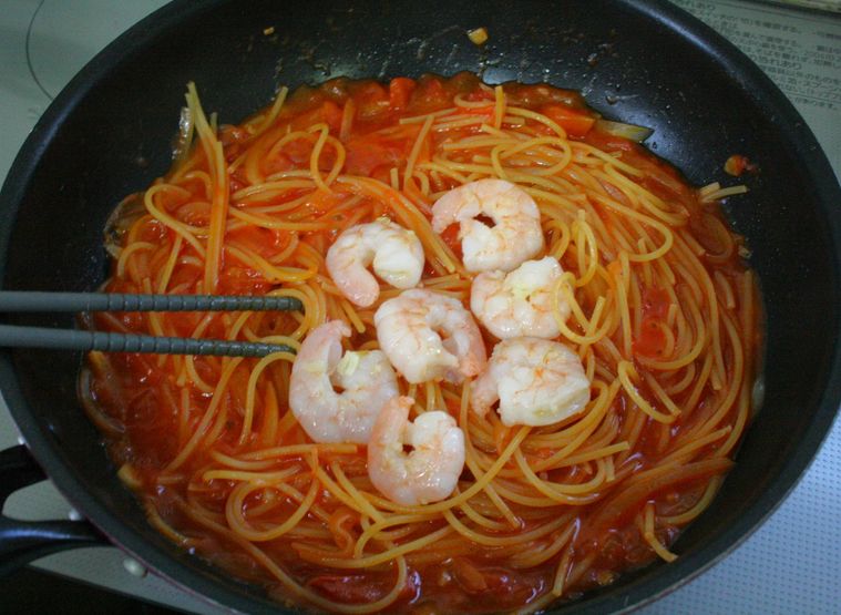 スパゲッティをゆでているフライパンに冷凍むきえびを入れた様子