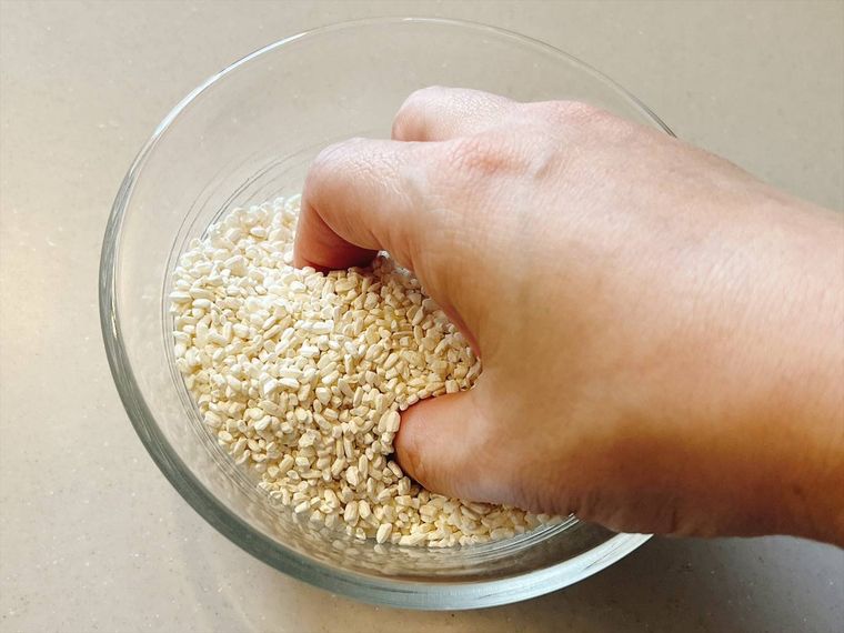 乾燥米麹を手でほぐしている