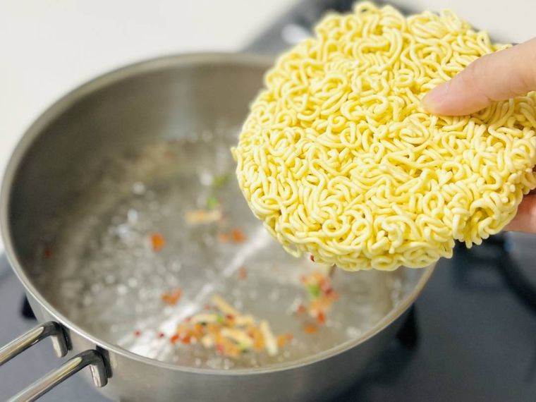 沸騰したお湯に辛ラーメンの麺を入れようとしている様子