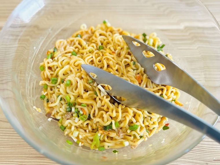 ゆでた麺にマヨネーズや小ねぎなどを混ぜた様子