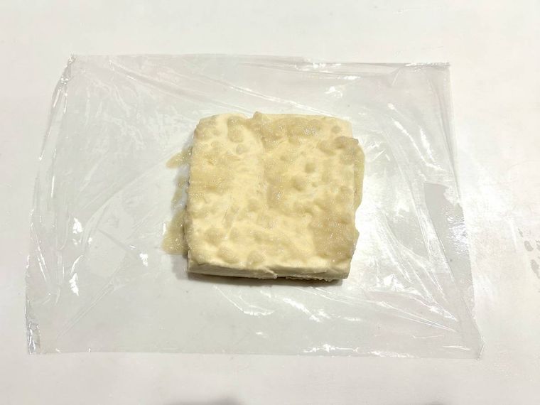 ラップを使って塩麹を豆腐に塗っている様子