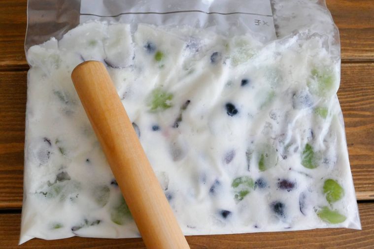 めん棒でフリーザーバッグに入っているぶどうとプレーンヨーグルトを叩く様子