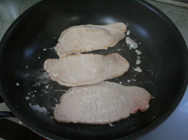 フライパンで焼いている豚ロース肉を裏返した様子