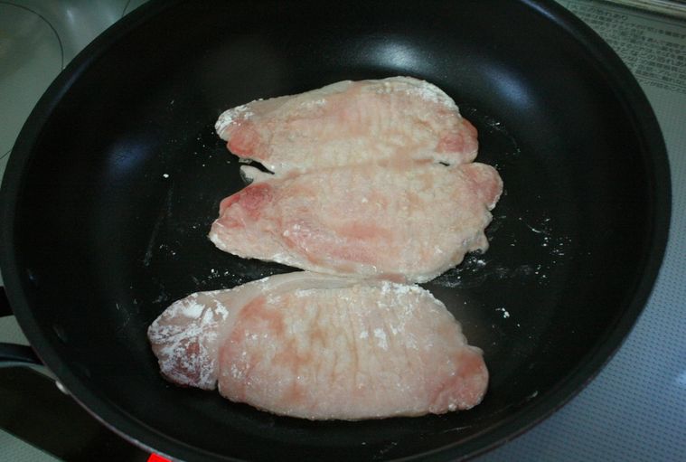 フライパンで豚ロース肉を3枚焼いている様子
