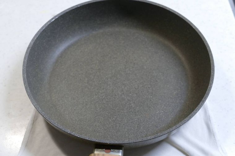 フライパンを濡れ布巾にのせて冷ます様子