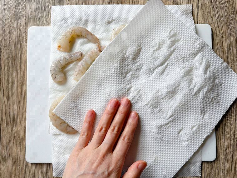 キッチンペーパーでえびを拭く様子