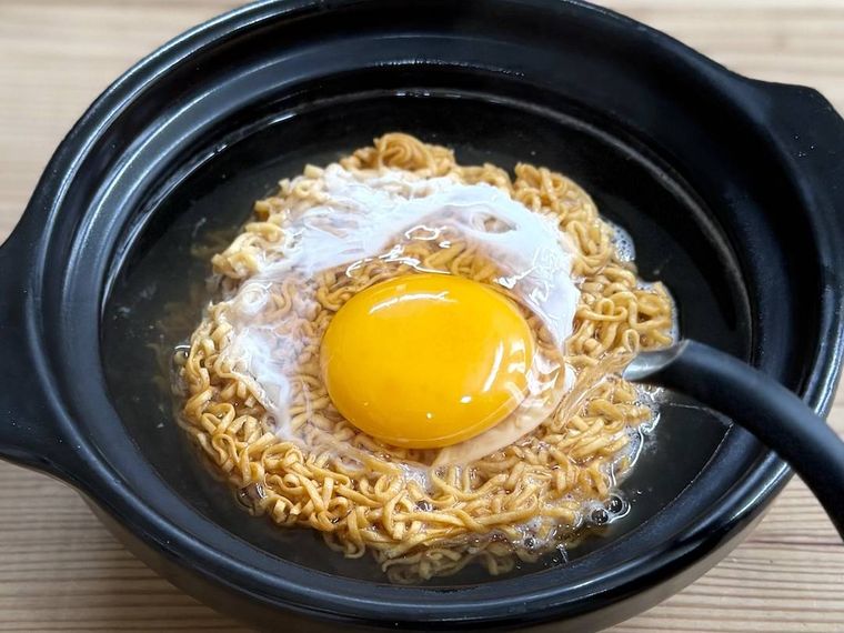 チキンラーメンの卵に熱湯を回しかけている様子