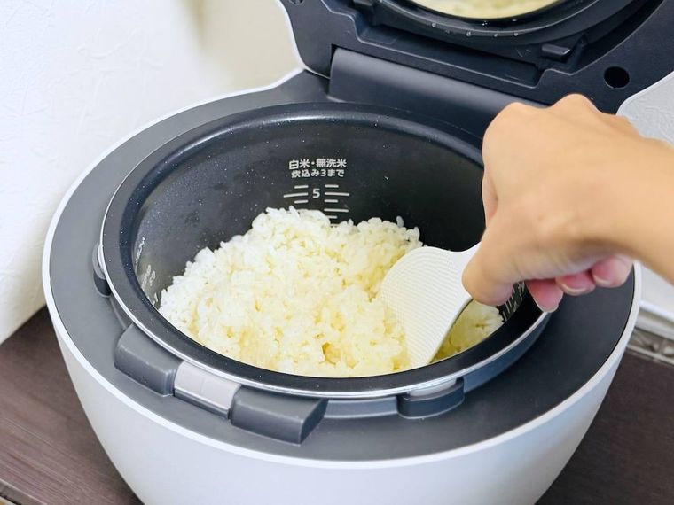 炊飯釜で炊いたバターライスをかき混ぜている様子