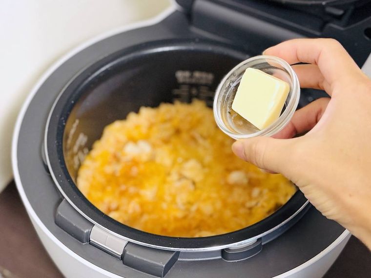 炊飯器で炊いたチキンライスにバターを加えようとしている様子
