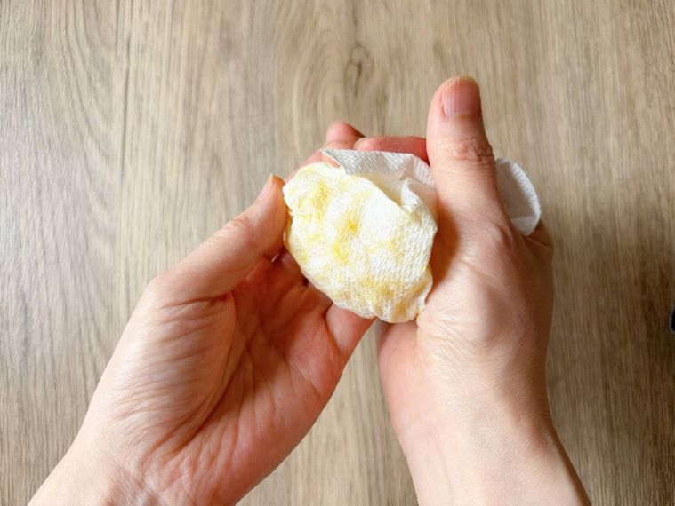 キッチンペーパーで包んだたくあんを軽く絞る様子