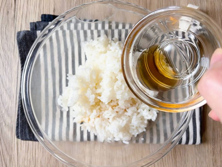 ごはんにごま油をまわしかける様子