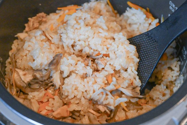 しゃもじで混ぜている炊飯が完了した炊き込みごはん