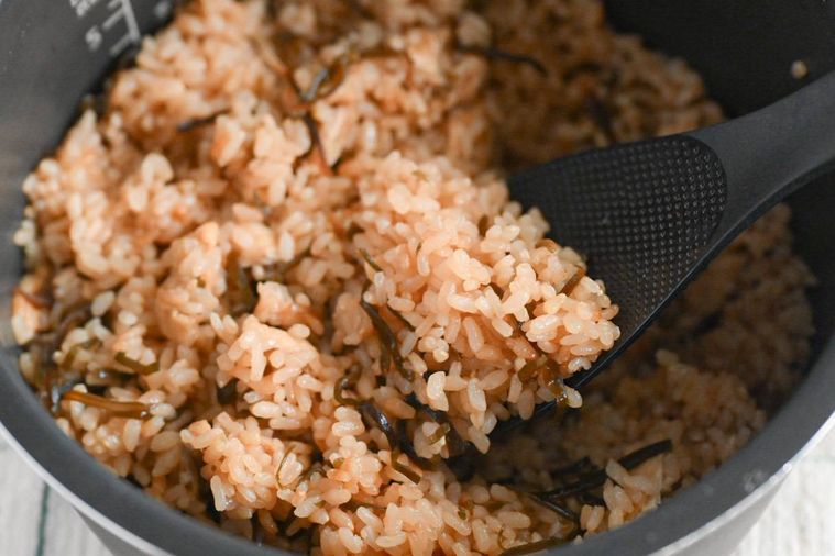 しゃもじで混ぜている塩昆布の炊き込みご飯