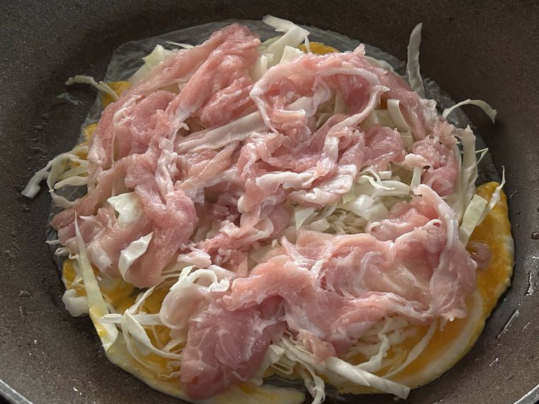 ライスペーパーの上に千切りキャベツと豚肉を広げたところ