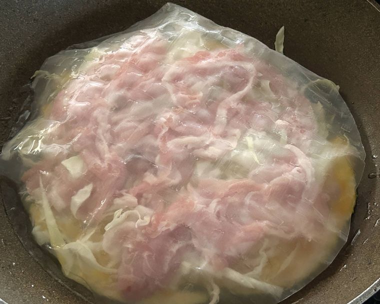 千切りキャベツと豚肉の上にライスペーパーを上からかぶせたところ