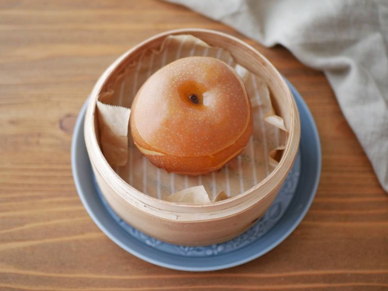 はちみつを注いだ梨がせいろに入っている様子