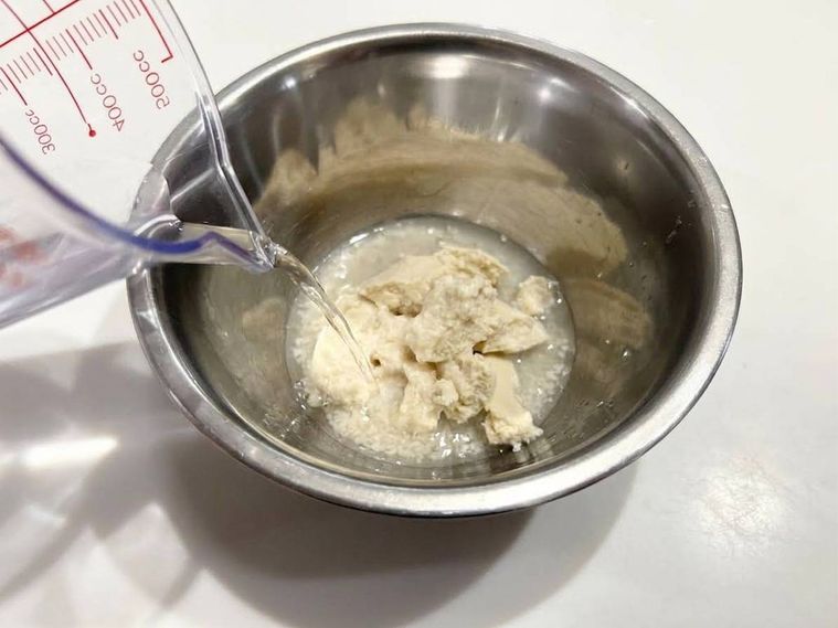 酒かすの入ったボウルに水を注ぐ様子