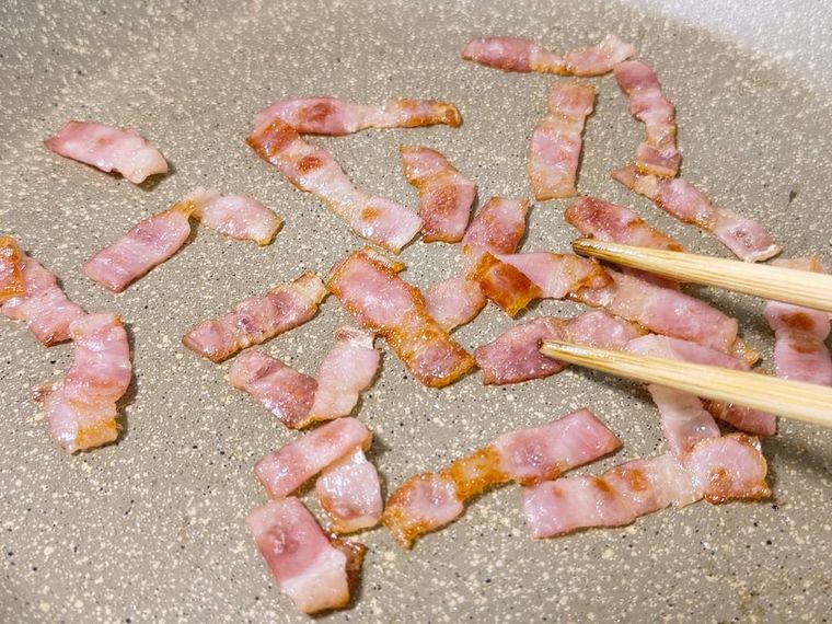 フライパンでベーコンを炒めている様子