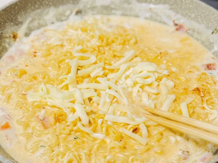 牛乳と水で煮た辛ラーメンにチーズを加えた様子