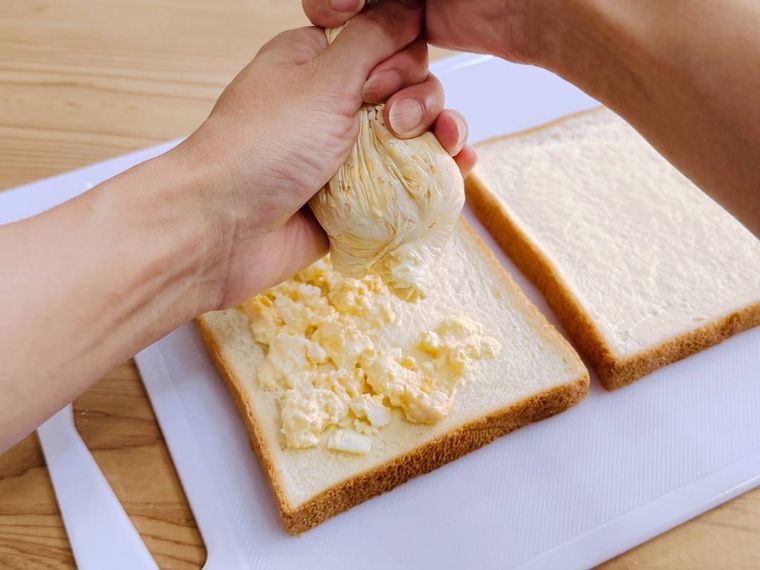 食パンに卵サラダを絞り出している様子