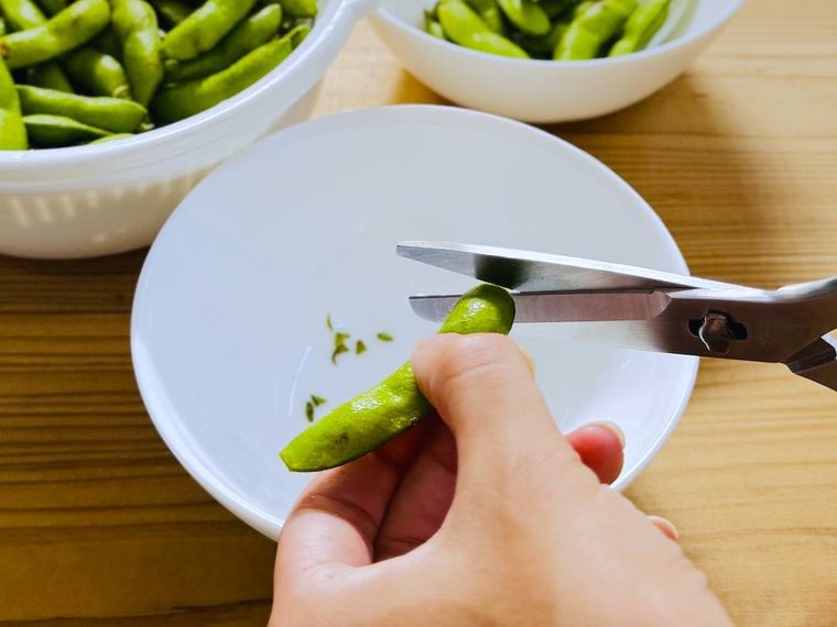 枝豆のさやの両端を切り落としている様子