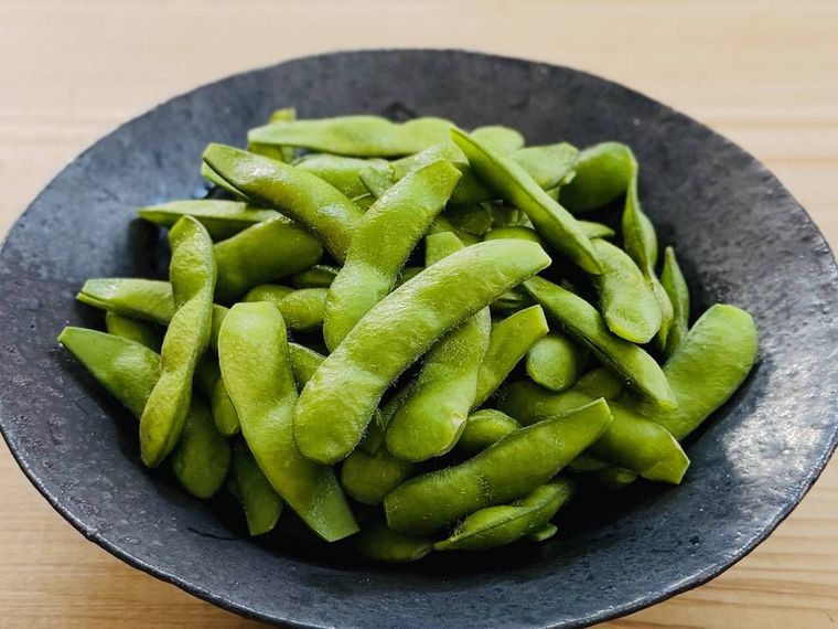 加熱した枝豆を黒い皿に盛り付けた様子