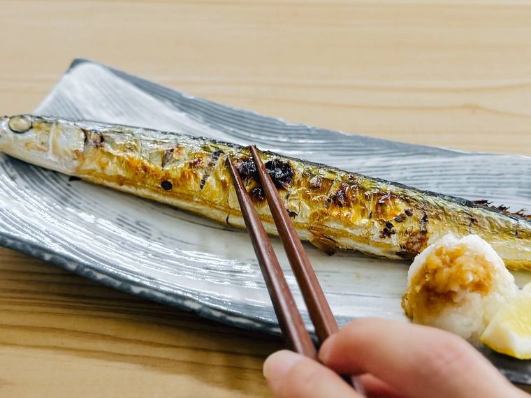 焼きさんまの身を箸で押さえている様子