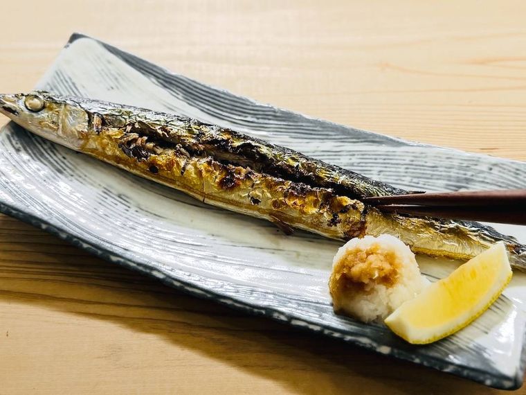 焼きさんまの身に切れ目を入れている様子