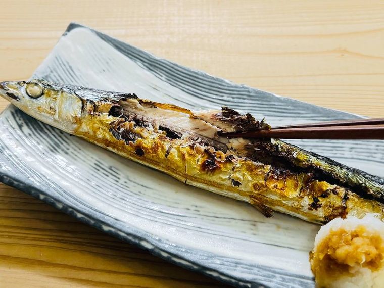 焼きさんまの身を箸でつかんだ様子
