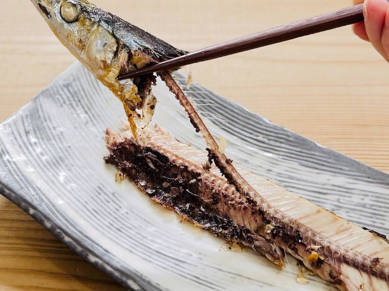 焼きさんまの中骨を外している様子