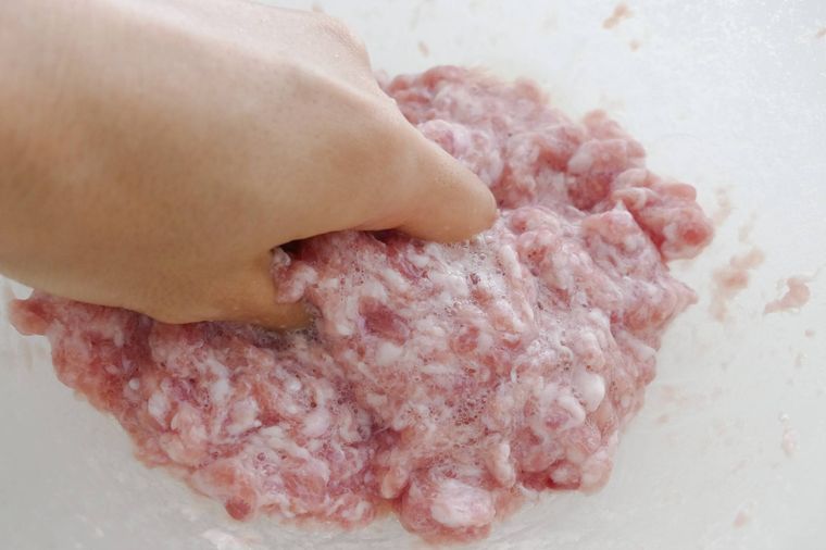 とろっとした肉だねを手で混ぜる様子