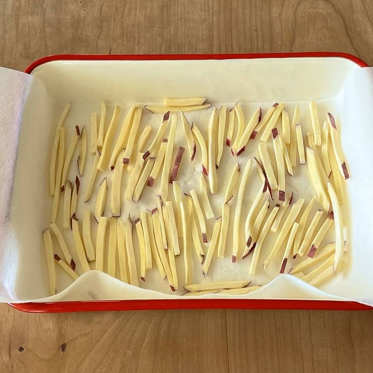 キッチンペーパーをひいたバットに棒状に切られたさつまいもが並んでいる