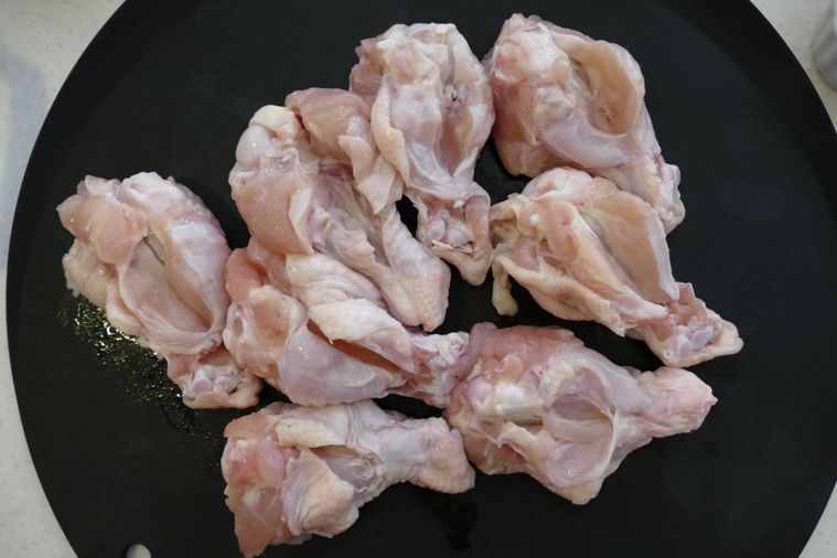 鶏手羽元に包丁で切り込みを入れる様子