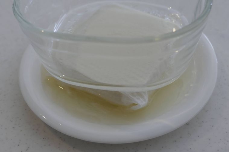 絹豆腐に重しをのせて水切りをする様子