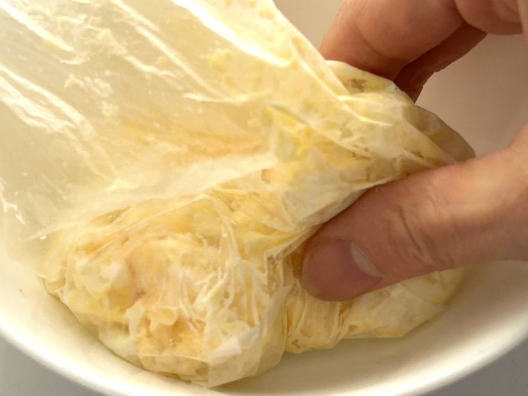 アイラップに入っているたまごサラダと調味料を手でもんで混ぜているところ