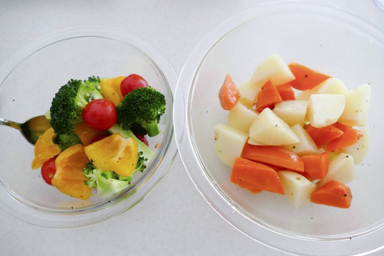 火の通りやすい野菜と火の通りにくい野菜を分けて調味料をまぶす様子