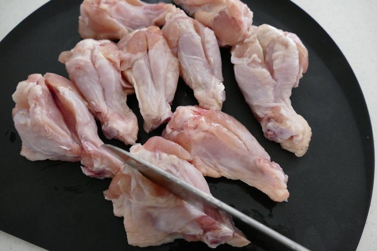 鶏手羽元に包丁で切り込みを入れる様子
