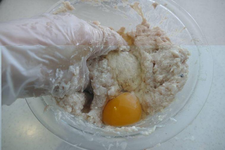 タネに絹豆腐と卵、玉ねぎを加えて混ぜる様子