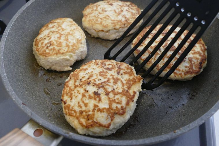焼き色がついた豆腐ハンバーグをフライ返しで返した様子