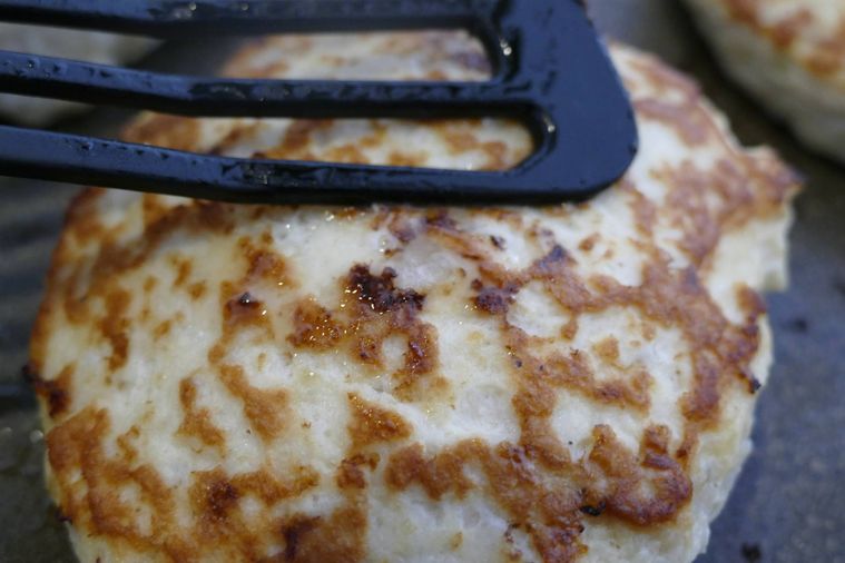 豆腐ハンバーグをフライ返しで押し、火の通りを確認する様子