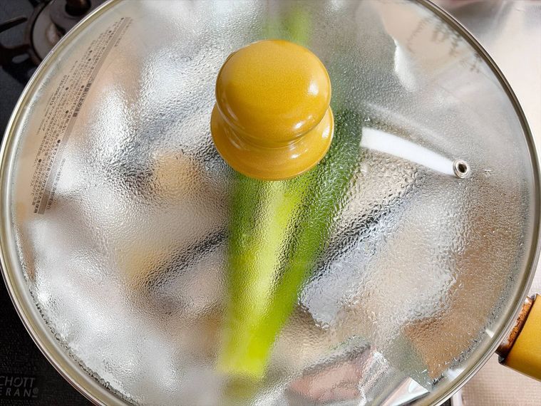 さんまとしょうが、長ねぎを入れたフライパンに蓋をし弱火で蒸し焼きにする様子