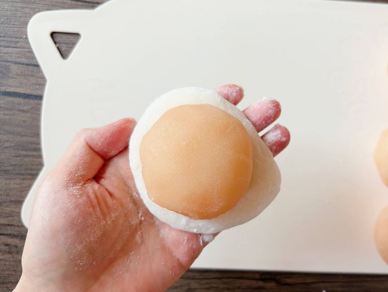 広げた求肥に白あんで包んだみかんをのせた様子