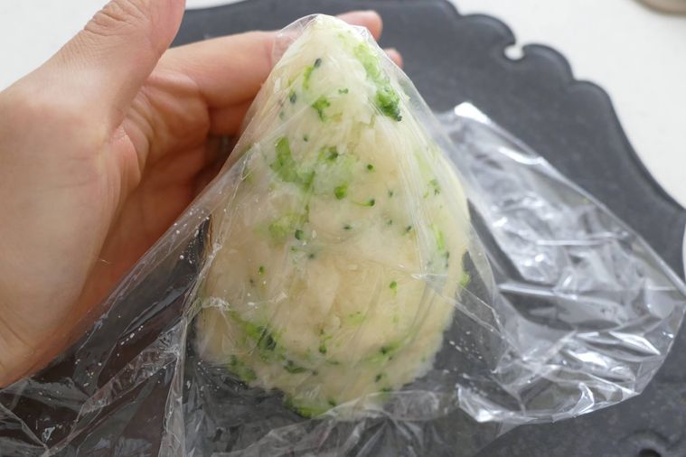 ラップごしに手でポテトサラダを円錐型に整える様子