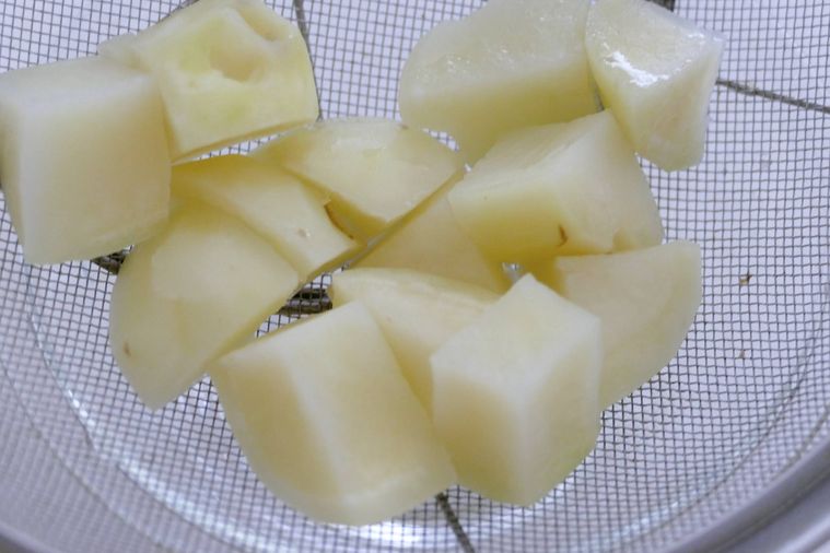 加熱したじゃがいもをザルにあげる様子