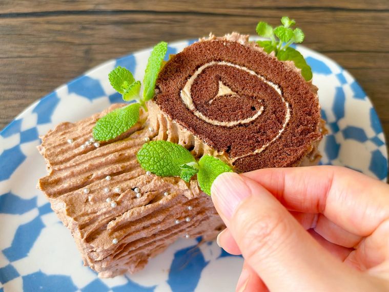 ロールケーキにハーブをのせる様子