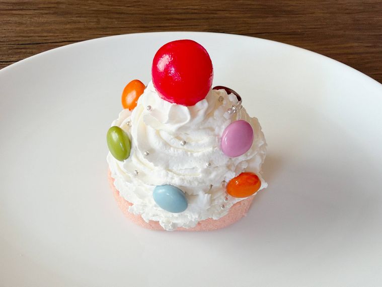 ホイップを絞り、チョコレートやアラザン、チェリーを飾った様子