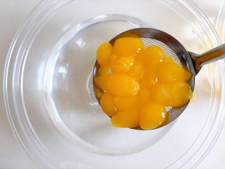 ザルですくって洗浄用の氷水に入れる様子
