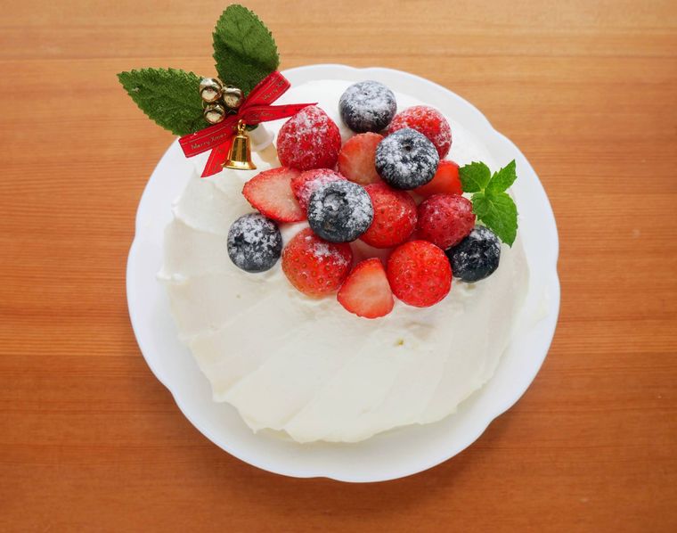 クリームを塗ったスポンジにフルーツを飾る様子